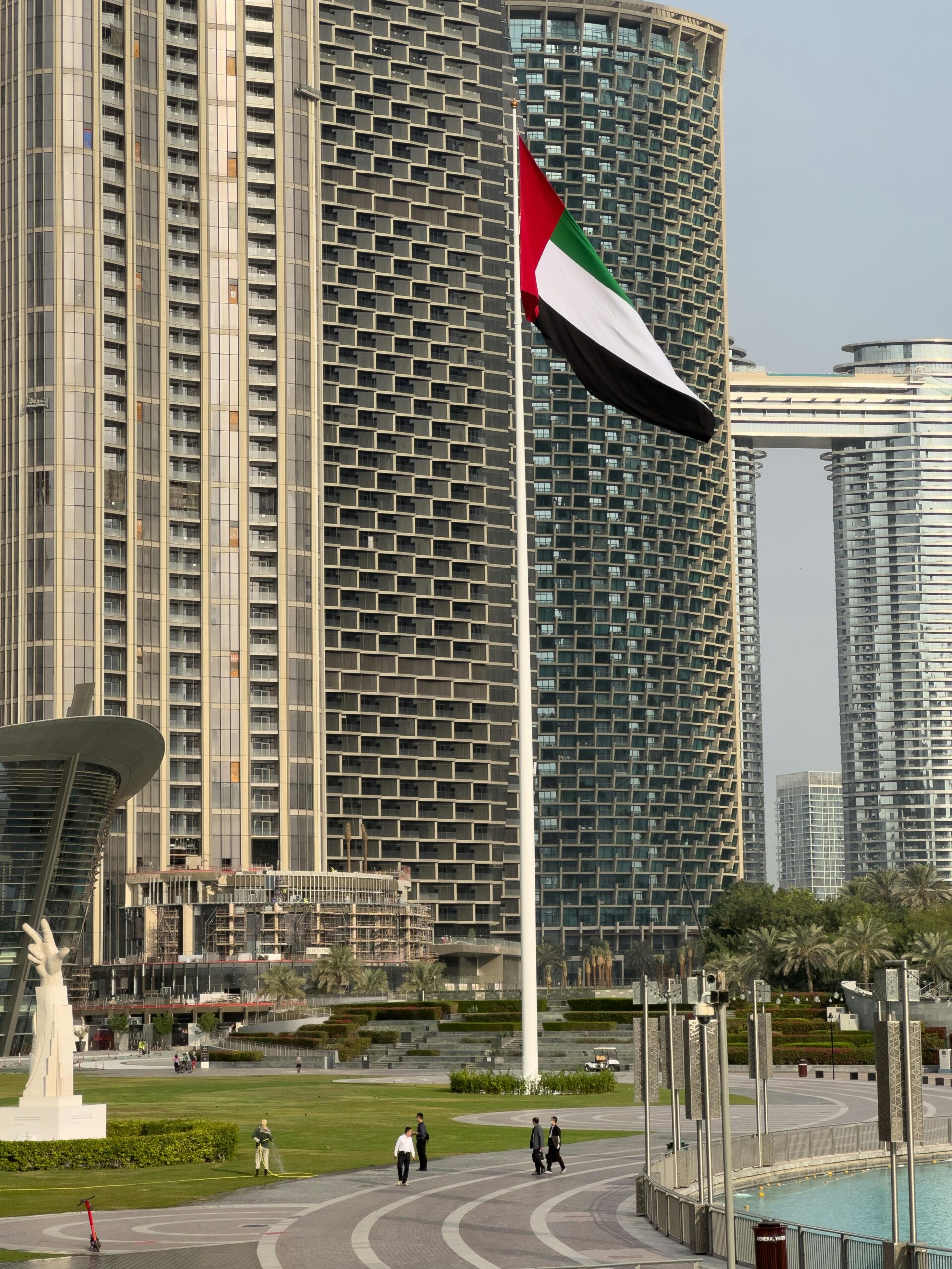 Elegant Dubai skyscraper view with UAE flag flapping, showcasing urban architecture.