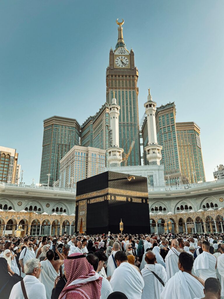 A large crowd of pilgrims gathered around the Kaaba with the iconic clock tower in Makkah, Saudi Arabia.