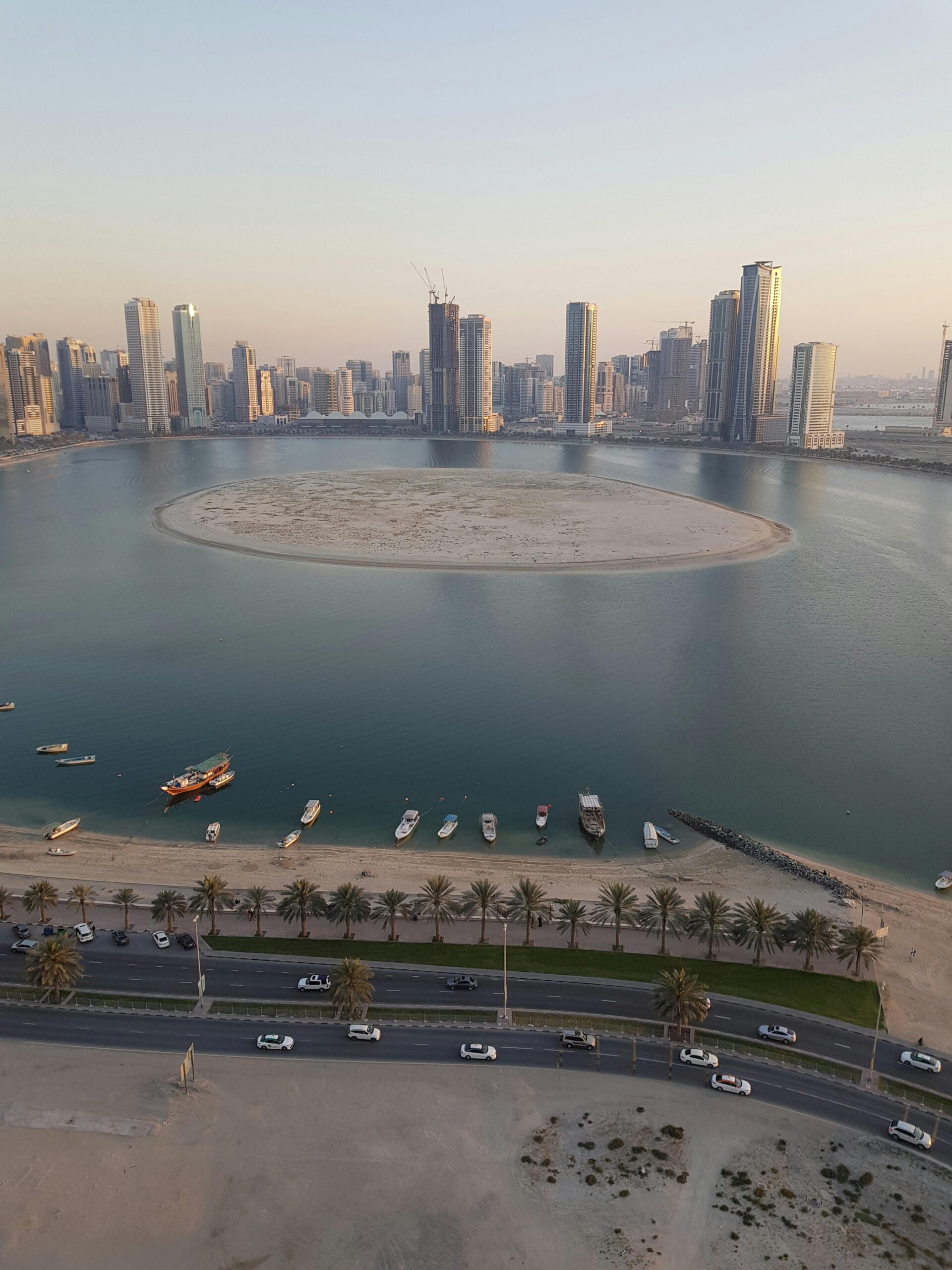 Stunning aerial shot of Al Khan Lagoon and Sharjah skyline during the day showcasing urban architecture.
